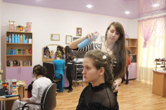Молодые парикмахеры делают работу мастеров